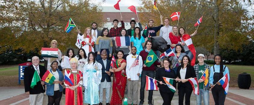 国际学生 in front of the 米切尔中心 with flags